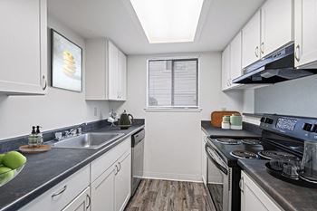 A modern kitchen with stainless steel appliances and white cabinets